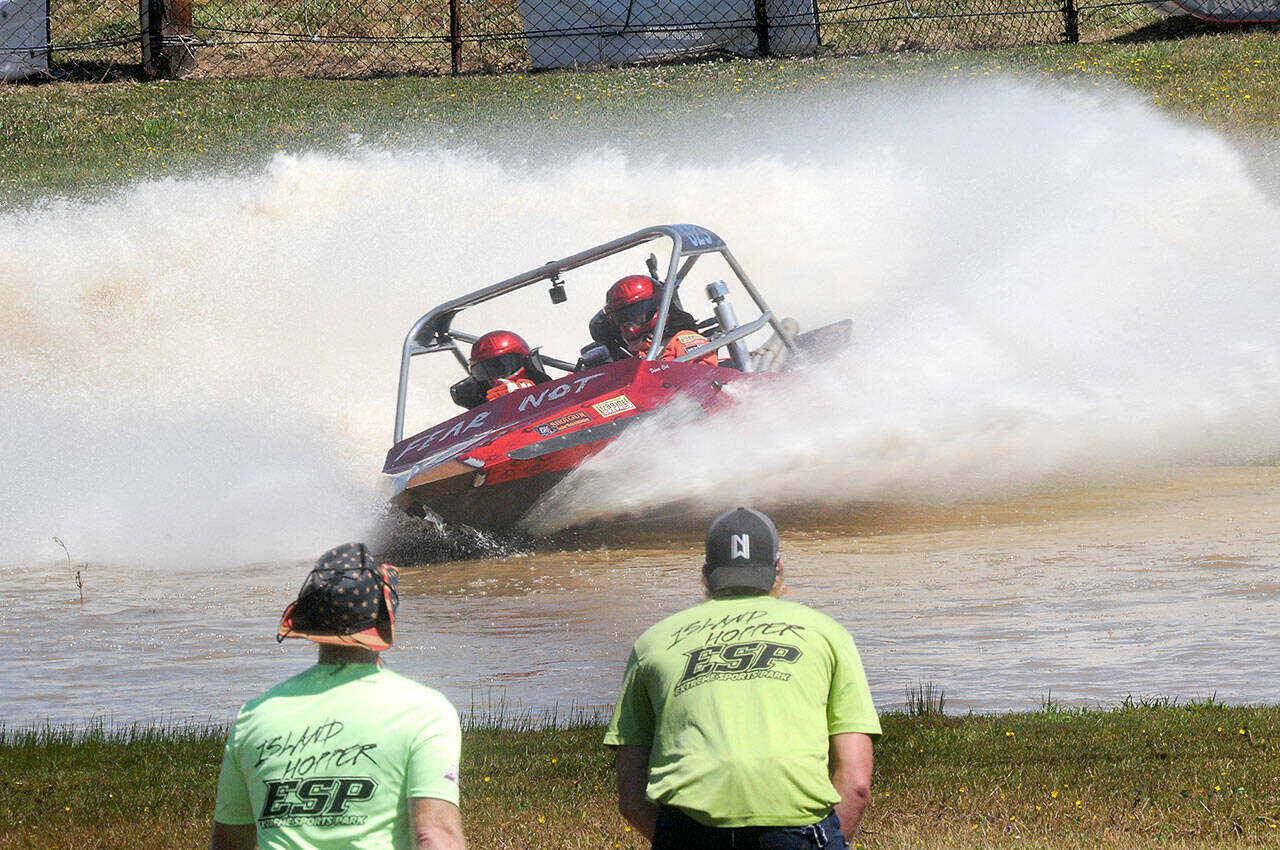 The Fear Not sprint boat driven by Clint Birch and navigated by Terri Lovell speeds through the Extreme Sports Park course as a pair of “island hopper” safety crew members watch the action on Saturday in Port Angeles. (Keith Thorpe/Peninsula Daily News)