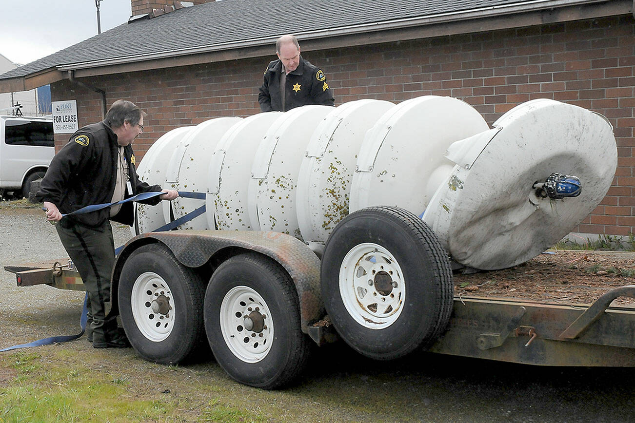 KEITH THORPE/PENINSULA DAILY NEWS
Clallam County Undersheriff Ron Cameron, left, and Patrol Sgt. John Keegan secure a crumpled tsunami siren to a trailer on Friday after it was toppled from its support pole on Marine Drive in Port Angeles by a traffic crash early Friday morning.