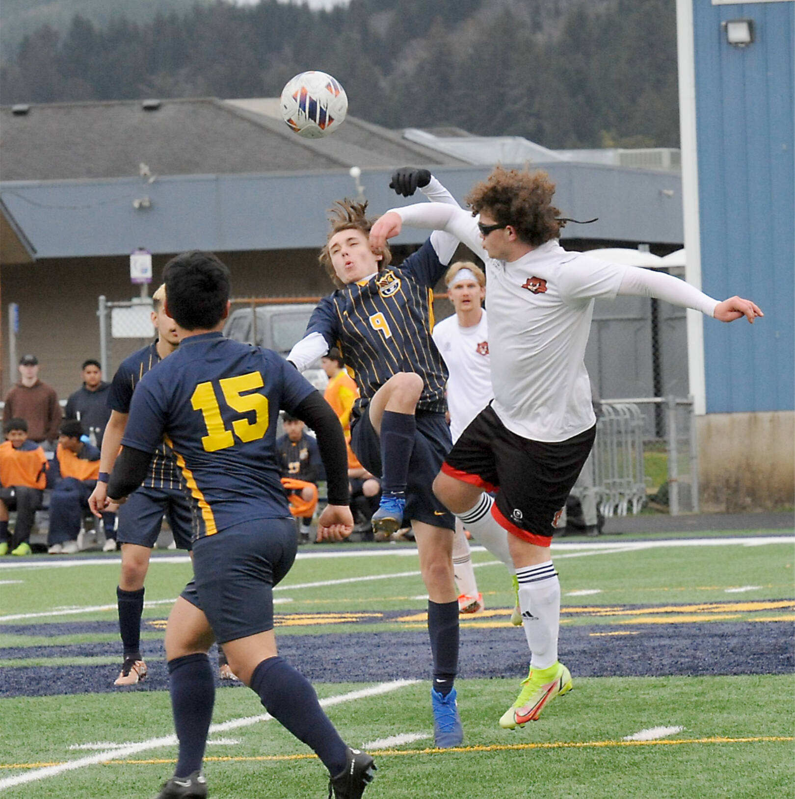 Forks’ Brody Owen (9) challenges Tenino’s Tyle Minerich for ball control Monday evening in Forks in the only sporting event of the day on the Peninsula with heavy rain most of the day. Also in the action is Spartan Kevin Udave-Ramos (15). Tenino won the match 5-3. (Lonnie Archibald/for Peninsula Daily News)