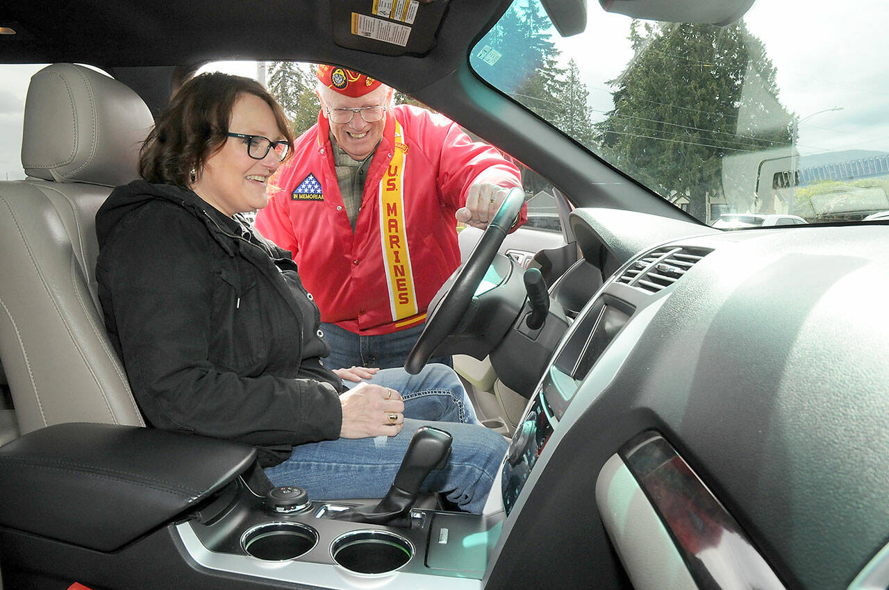 Cheri Tinker, executive director of Forks-based Sarge’s Veterans Support, front, looks over the features of a donated van with Mark Schildknecht, commandant of Mount Olympus Detatchmet 897 of the Marine Corps League after turning over the keys on Thursday at the Northwest Veterans Resource Center in Port Angeles. (KEITH THORPE/PENINSULA DAILY NEWS)