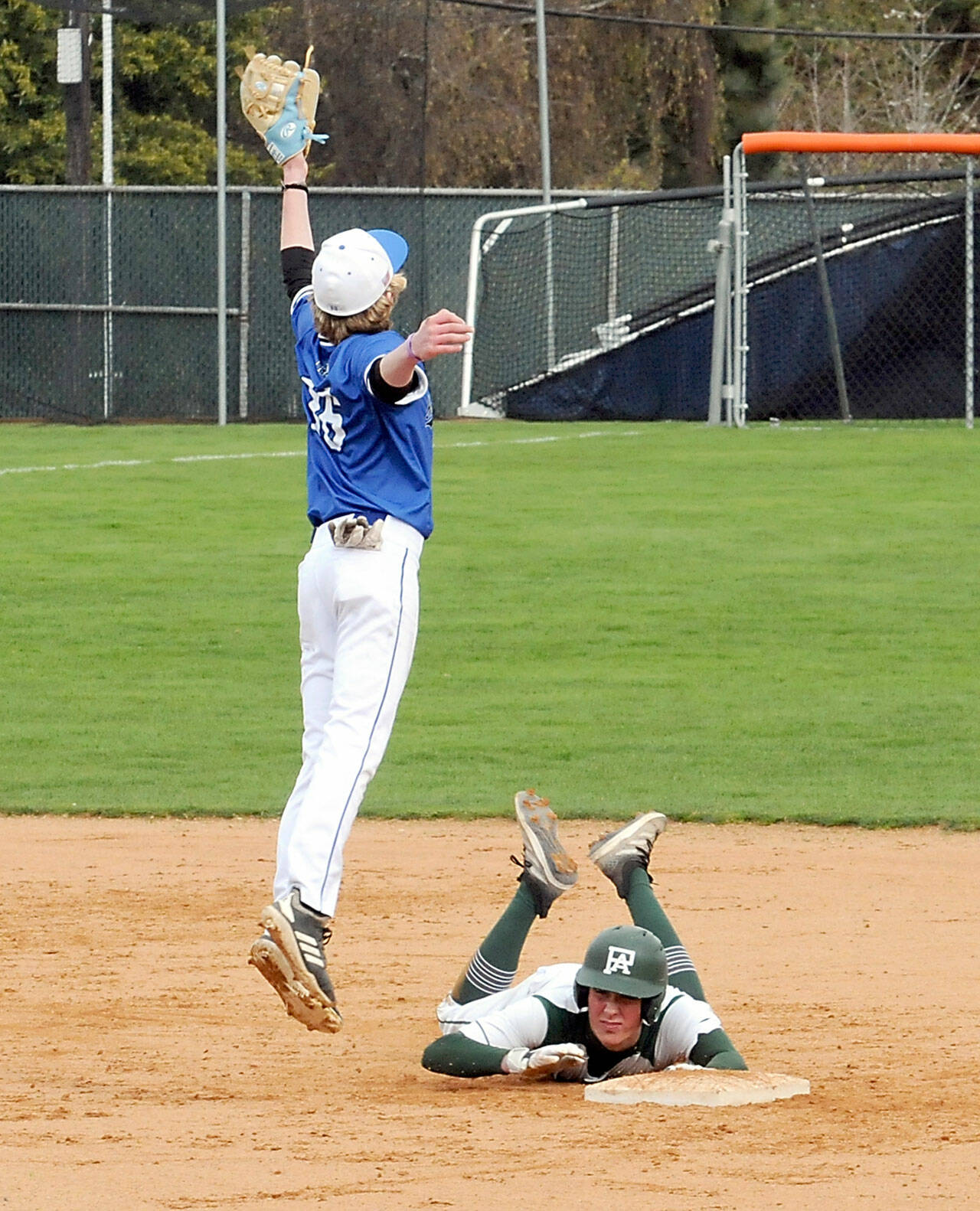 Port Angeles’ Kole Acker scrambles back to second after tripping while rounding the bag while North Mason shortstop Dylan Prideaux reaches for the throw from the outfield on Tuesday at Port Angeles Civic Field. (Keith Thorpe/Peninsula Daily News)