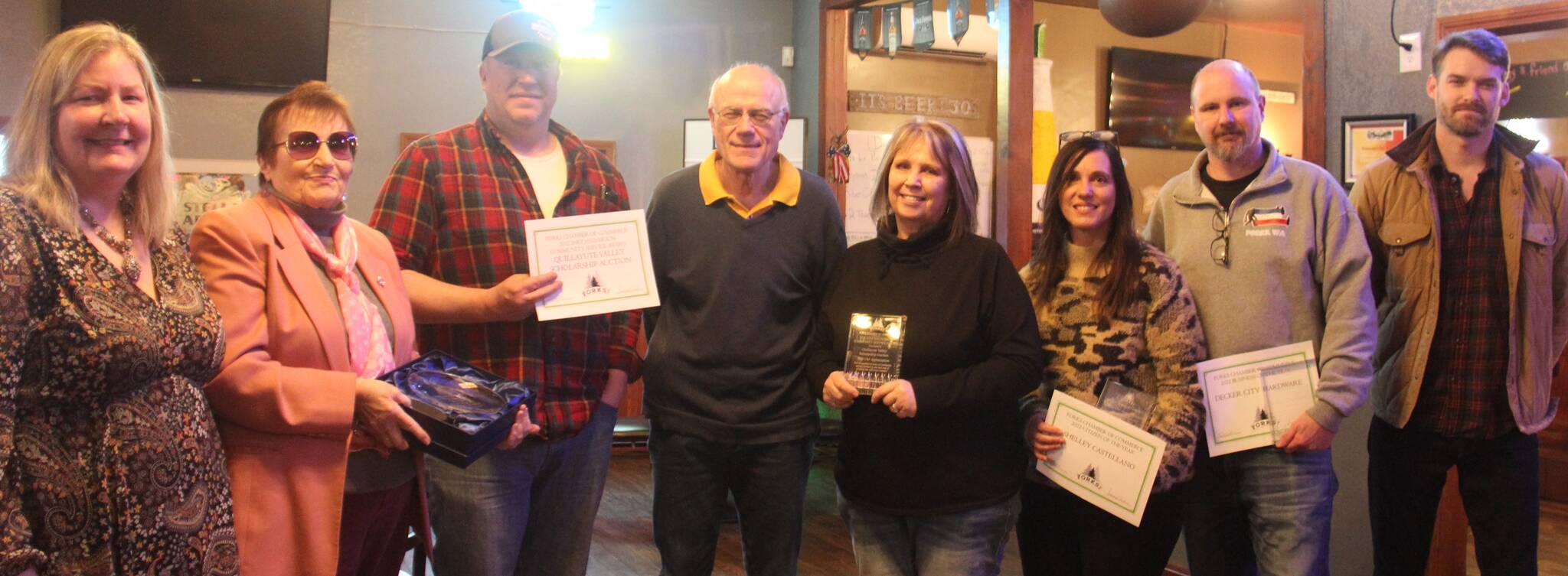 Pictured from left are Forks Chamber of Commerce Executive Director Lissy Andros, Cornerstone Award recipient Nedra Reed, Wes Romberg, Bill Brager and JoMarie Miller accepting the Halvie Award on behalf of the Quillayute Valley Scholarship Auction, Citizen of the Year Shelley Castellano, Business of the Year award winner Dean Decker, and Forks Chamber President Trent Thurman. Not pictured are Deborah Scannell and Jerry Leppell. (Christi Baron/Olympic Peninsula News Group)