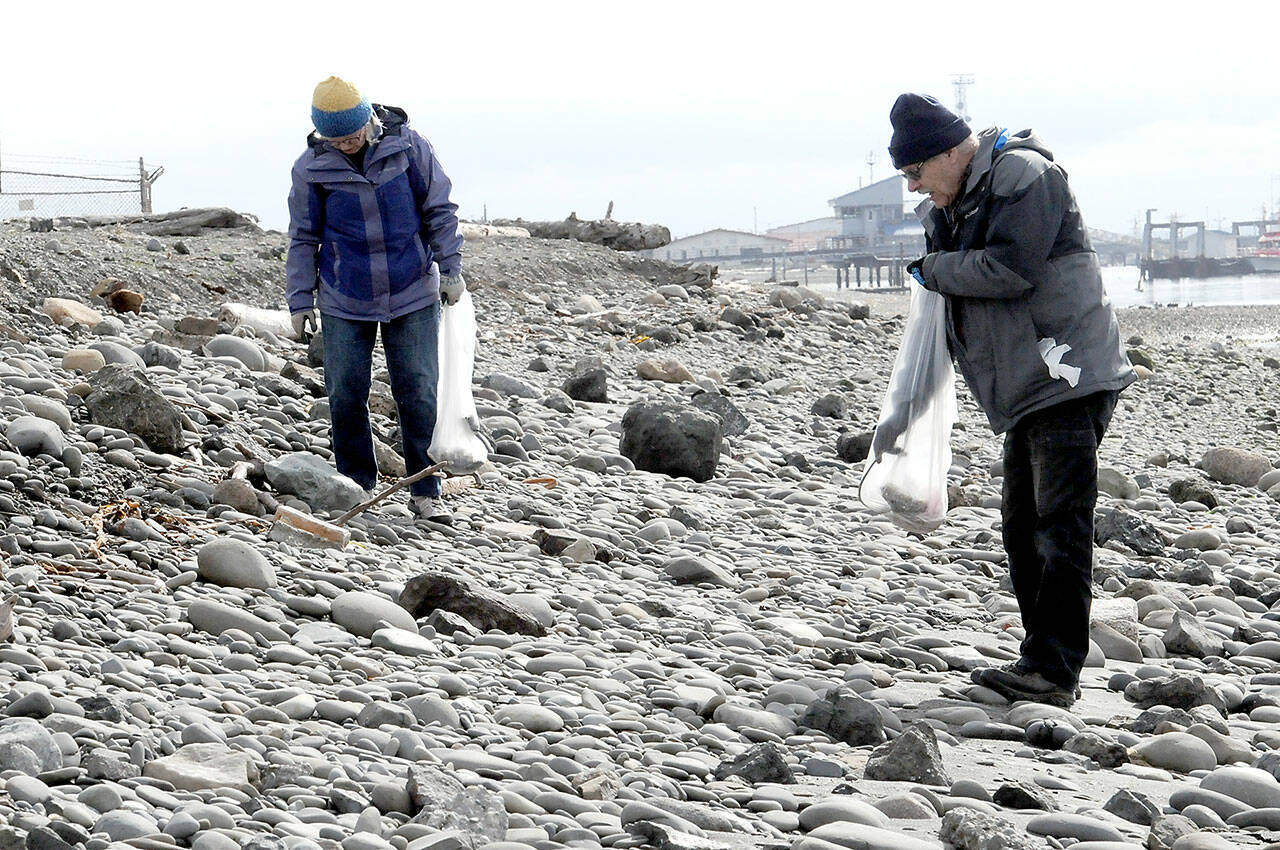 Joan Mickelson of Anacortes, left, and Doug Atterbury of Port Angeles scour the shores of Port Angeles Harbor on Ediz Hook on Saturday looking for refuse as an Earth Day activity in Port Angeles. Washington CoastSavers and Olympic National Park, as well as several other organizations, hosted beach cleanups across the North Olympic Peninsula. (Keith Thorpe/Peninsula Daily News)