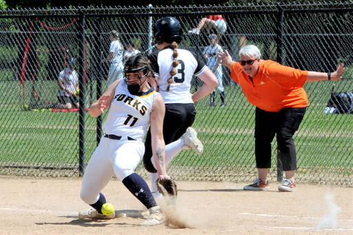 Rainier assistant coach Kayla Mounts, right, helps the umpire with the safe call at first base as Mountaineers runner Brooklyn Swenson reaches first on a wild throw. Forks first baseman Kaidence Rigby reaches for the ball in the dirt during the game played at Borst Park in Centralia, where Forks defeated Rainier 6-2 in 2B District 1/4 play. (Lonnie Archibald/for Peninsula Daily News)