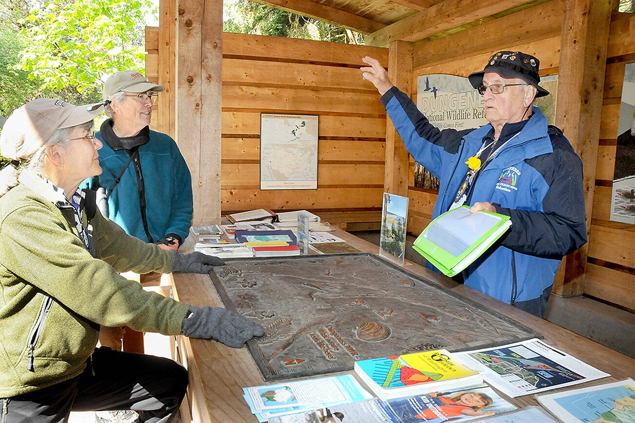 KEITH THORPE/PENINSULA DAILY NEWS
Martin Gutowski, a volunteer with the Dungeness National Wildlife Refuge, right, discusses  features and attractions of the North Olympic Peninsula with Jan and Bob Tivel of Anacortes at the refuge's information kiosk northwest of Sequim. Besides being a sanctuary for birds and other wildlife, the refuge serves as gateway to the Dungeness Spit and the New Dungeness Lighthouse.