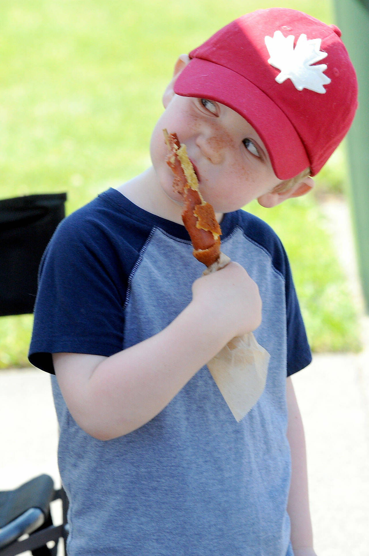 James Hershmiller, 3, of Port Angeles gnaws on a corn dog on Friday at the Juan de Fuca Festival street fair in Port Angeles. (KEITH THORPE/PENINSULA DAILY NEWS)