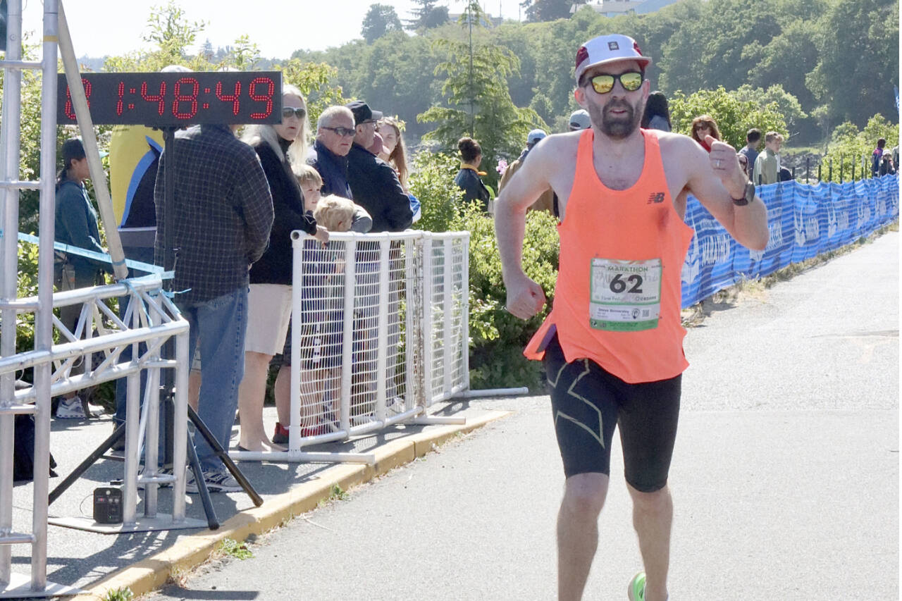 Derek Binnersley of Victoria, B.C., crosses the finish line as the winner of the North Olympic Discovery Marathon. Binnersley, running his first marathon, won in a time of 2 hours, 48 minutes, 47.51 seconds, winning by more than 5 minutes. (Dave Logan/for Peninsula Daily News)