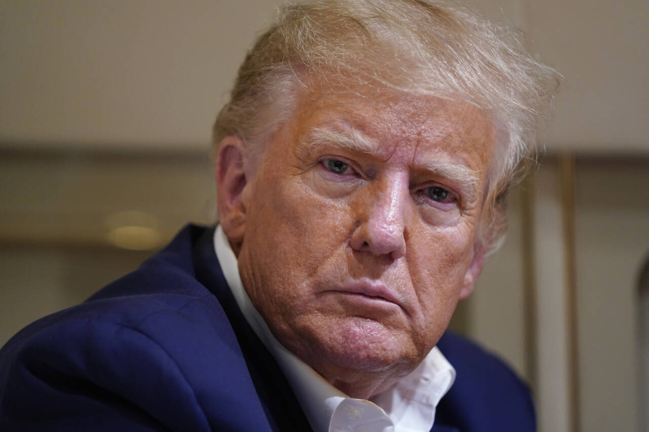 Former President Donald Trump listens as he speaks with reporters while in flight on his plane after a campaign rally at Waco Regional Airport, in Waco, Texas, March 25, while en route to West Palm Beach, Fla. (AP Photo/Evan Vucci, File)