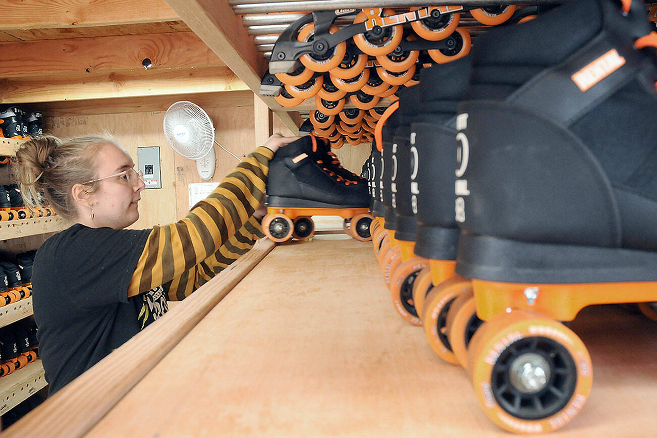 Volunteer Laken Folsom stocks shelves with skates on Tuesday in preparation for Friday’s official opening of the Olympic Skate Village and its seasonal roller skating rink in the 100 block of West Front Street in downtown Port Angeles. The village, operated by the Port Angeles Regional Chamber of Commerce and staffed by volunteers, will offer three daily sessions of skating through Aug. 14. Admission is $10 per session or $8 per session if you bring your own skates. (Keith Thorpe/Peninsula Daily News)