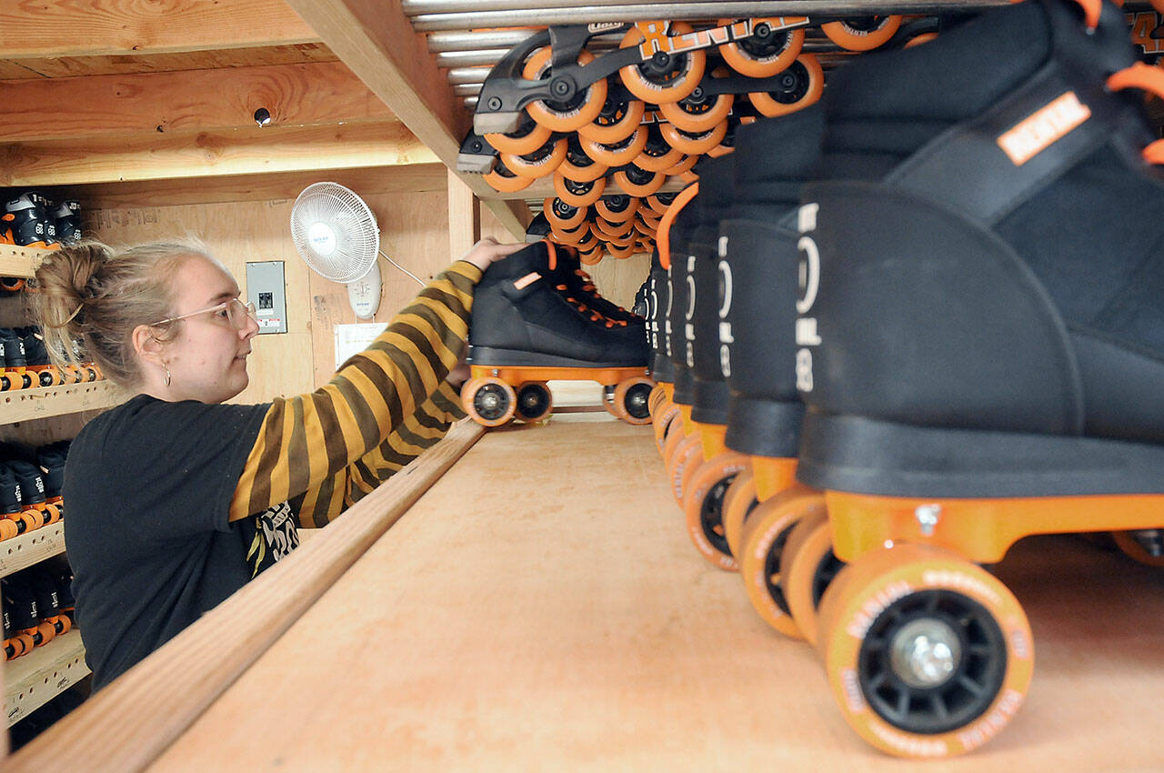 Volunteer Laken Folsom stocks shelves with skates on Tuesday in preparation for Friday’s official opening of the Olympic Skate Village and its seasonal roller skating rink in the 100 block of West Front Street in downtown Port Angeles. The village, operated by the Port Angeles Regional Chamber of Commerce and staffed by volunteers, will offer three daily sessions of skating through Aug. 14. Admission is $10 per session or $8 per session if you bring your own skates. (Keith Thorpe/Peninsula Daily News)