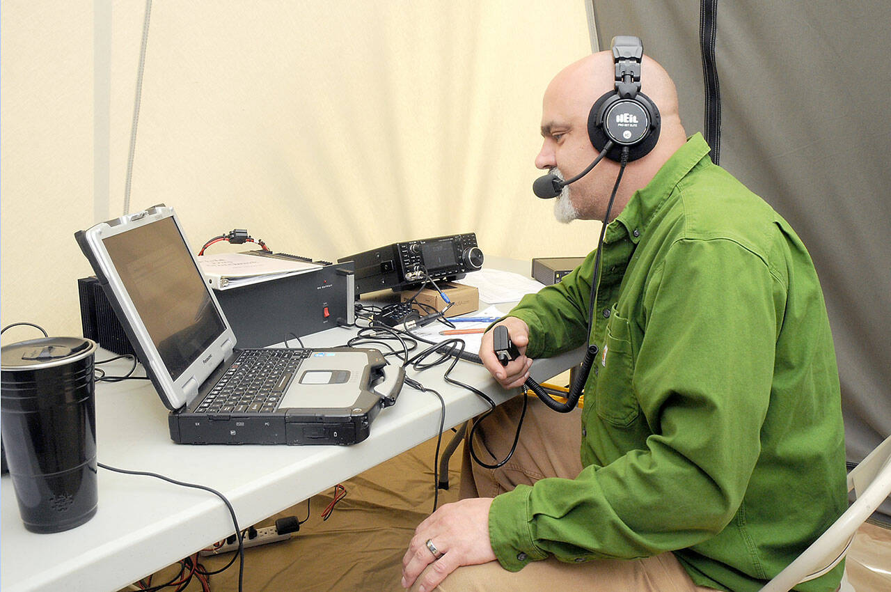 Radio operator Chris Icide of Joyce, who uses the call sign WY7W, talks to other radio stations while broadcasting from a tent on Saturday at the Clallam County Fairgrounds in Port Angeles as part of Field Day, an international competition where partcipants attempt to log as many contacts across the United States and Canada as possible in a 24-hour period. (KEITH THORPE/PENINSULA DAILY NEWS)