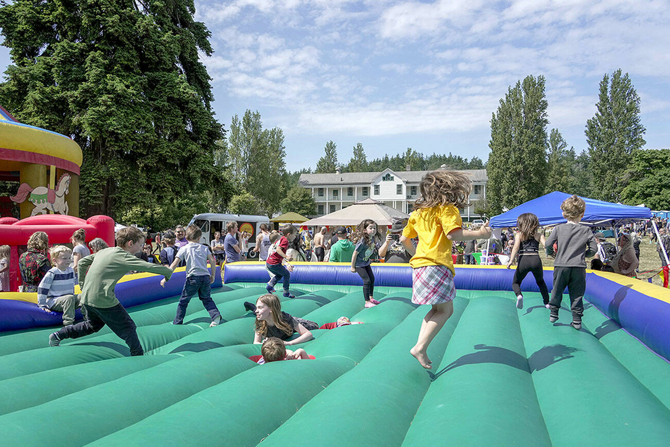 Kids get a kick out of the bouncy jumper at the free Field Day event at Fort Worden State Park on Saturday. The event included a range of games, prizes and live entertainment presented by The Production Alliance and Fort Worden Hospitality. (Steve Mullensky/for Peninsula Daily News)