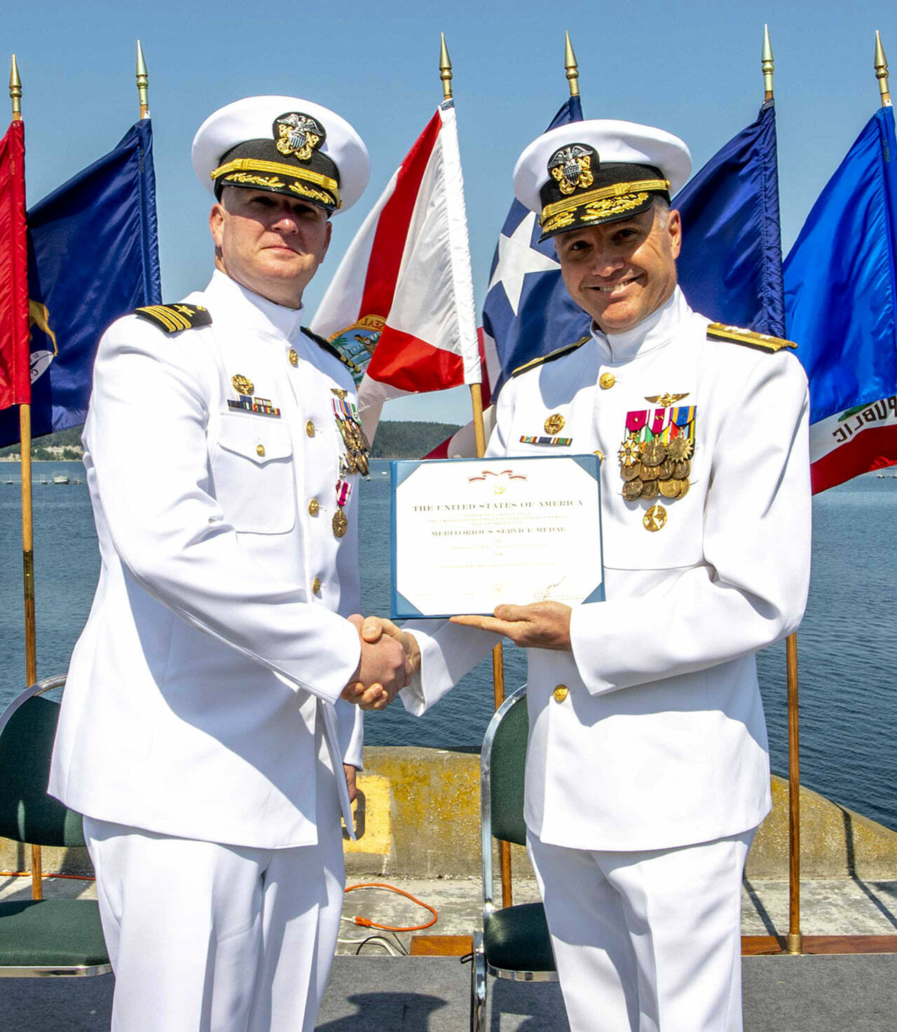 Navy Region Northwest Rear Admiral Mark Sucato, far right, shakes the hand of Cmdr. Todd Galvin as he takes command of Naval Magazine Indian Island.