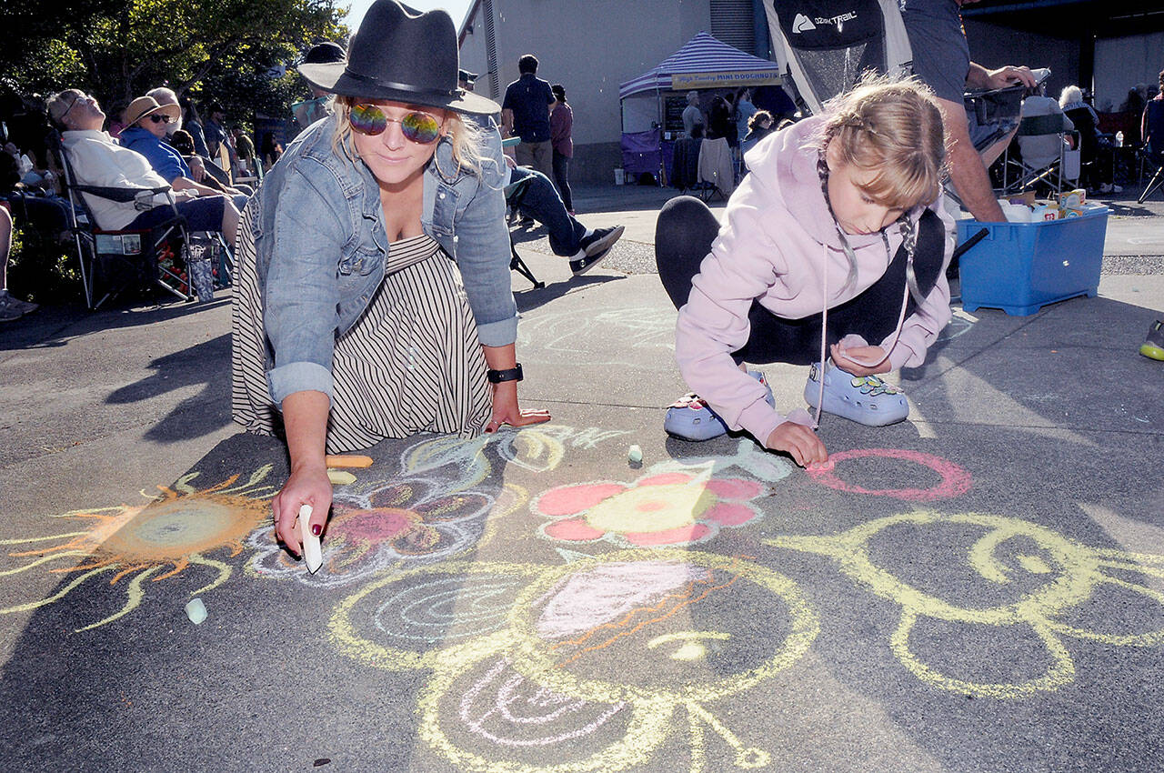 Melissa Preit of Port Angeles and her daughter, Avanelle Priet, 11, make chalk drawings on the sidewalk to the music of The Spin-Offs during Wednesday’s season-opening Concert on the Pier music series at Port Angeles City Pier. (KEITH THORPE/PENINSULA DAILY NEWS)