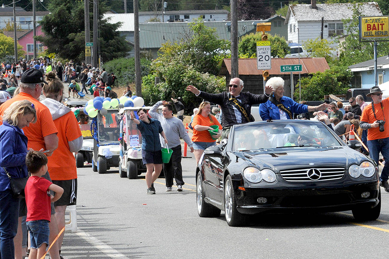 Wes Fitzpatrick and Lorna Konopaski, grand pioneers for the Clallam Bay-Sekiu Fun Days parade, wave to the crowd on Saturday. The three-day celebration ended Sunday with a beach cleanup, fun run, tournaments and other activities. (Lonnie Archibald/for Peninsula Daily News)