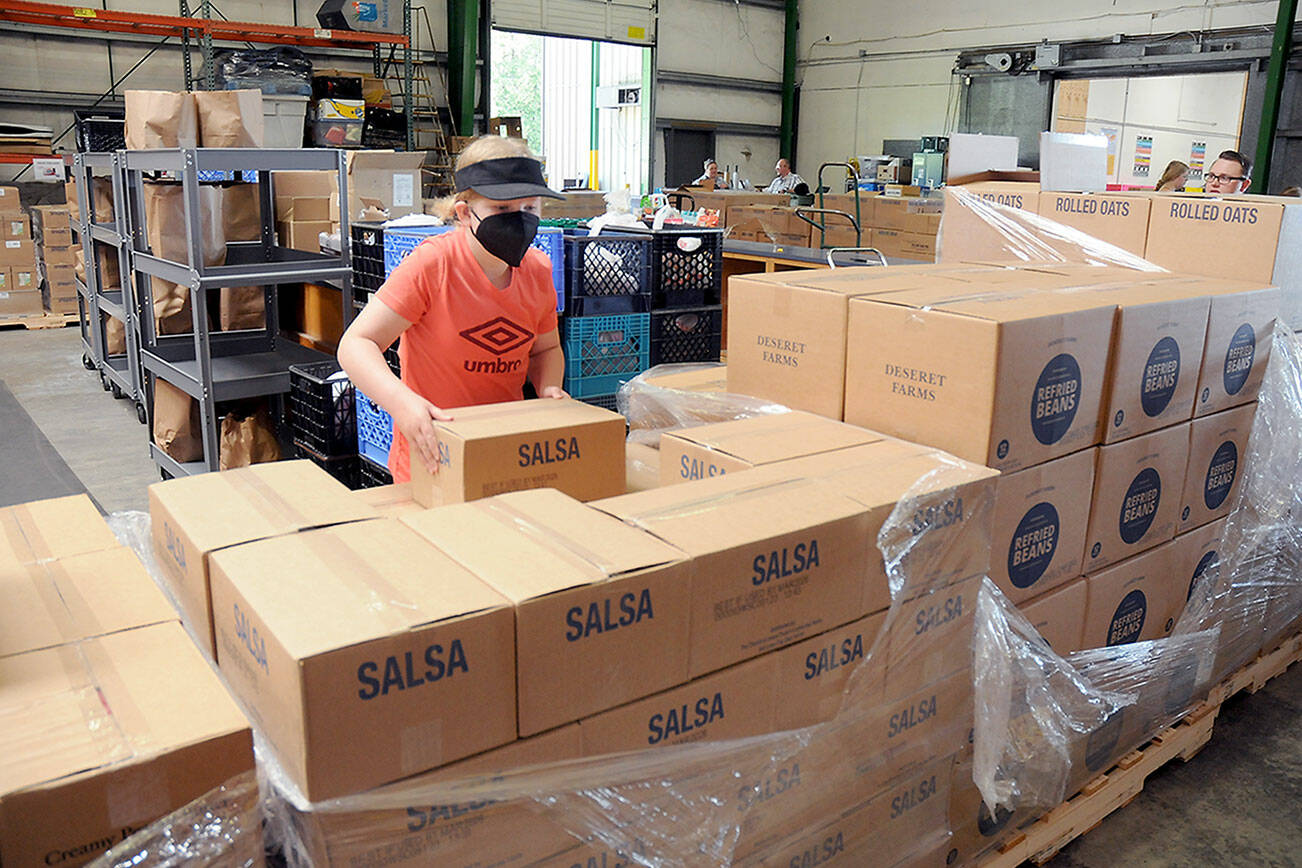 Ellie Hales, 11, of Port Angeles, a member of the Church of Jesus Christ of Latter Day Saints, helps sort boxes of food that were donated to the Port Angeles Food Bank by the Mormon Church’s food operations in Utah. A total of 24 pallets of food and personal items weighing about 20 tons were to be divided up by local church members for later distribution to food banks in Forks, Sequim and Port Townsend, as well as Port Angeles. (Keith Thorpe/Peninsula Daily News)