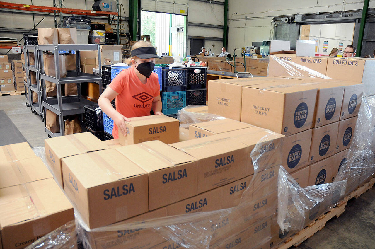 Ellie Hales, 11, of Port Angeles, a member of the Church of Jesus Christ of Latter Day Saints, helps sort boxes of food that were donated to the Port Angeles Food Bank by the Mormon Church’s food operations in Utah. A total of 24 pallets of food and personal items weighing about 20 tons were to be divided up by local church members for later distribution to food banks in Forks, Sequim and Port Townsend, as well as Port Angeles. (Keith Thorpe/Peninsula Daily News)