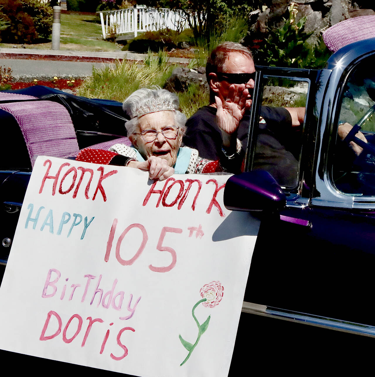 Doris Thompson celebrates her 105th birthday by checking off the next item on her bucket list — a ride in an fancy, old convertible — with the assistance of John Rudder of Port Angeles and his 1956 Pontiac. (Dave Logan/For Peninsula Daily News)