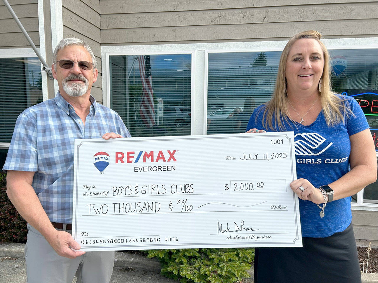 Pictured are Mark DeRousie of RE/MAX, and Janet Gray of the Boys & Girls Clubs.