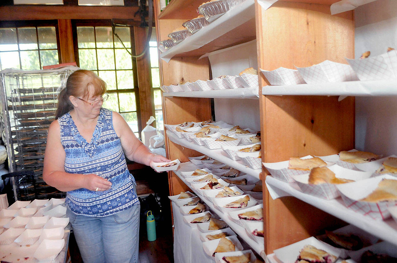 Cheryl Anderson of Joyce stages slices of blackberry pie for sale to the public at the Joyce Daze Wild Blackberry Festival in 2022. (Keith Thorpe/Peninsula Daily News)