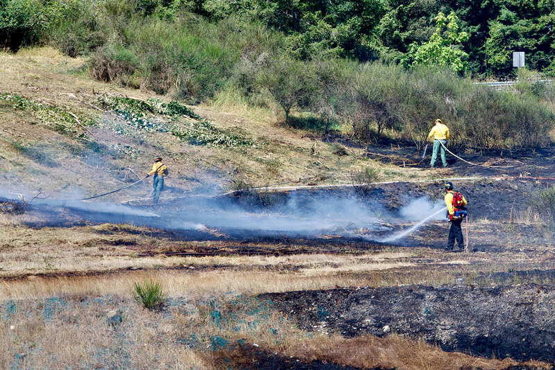 Firefighters work to contain a brush fire on the south side of U.S. Highway 101 near Deer Park on Monday. (Clallam 2 Fire-Rescue)