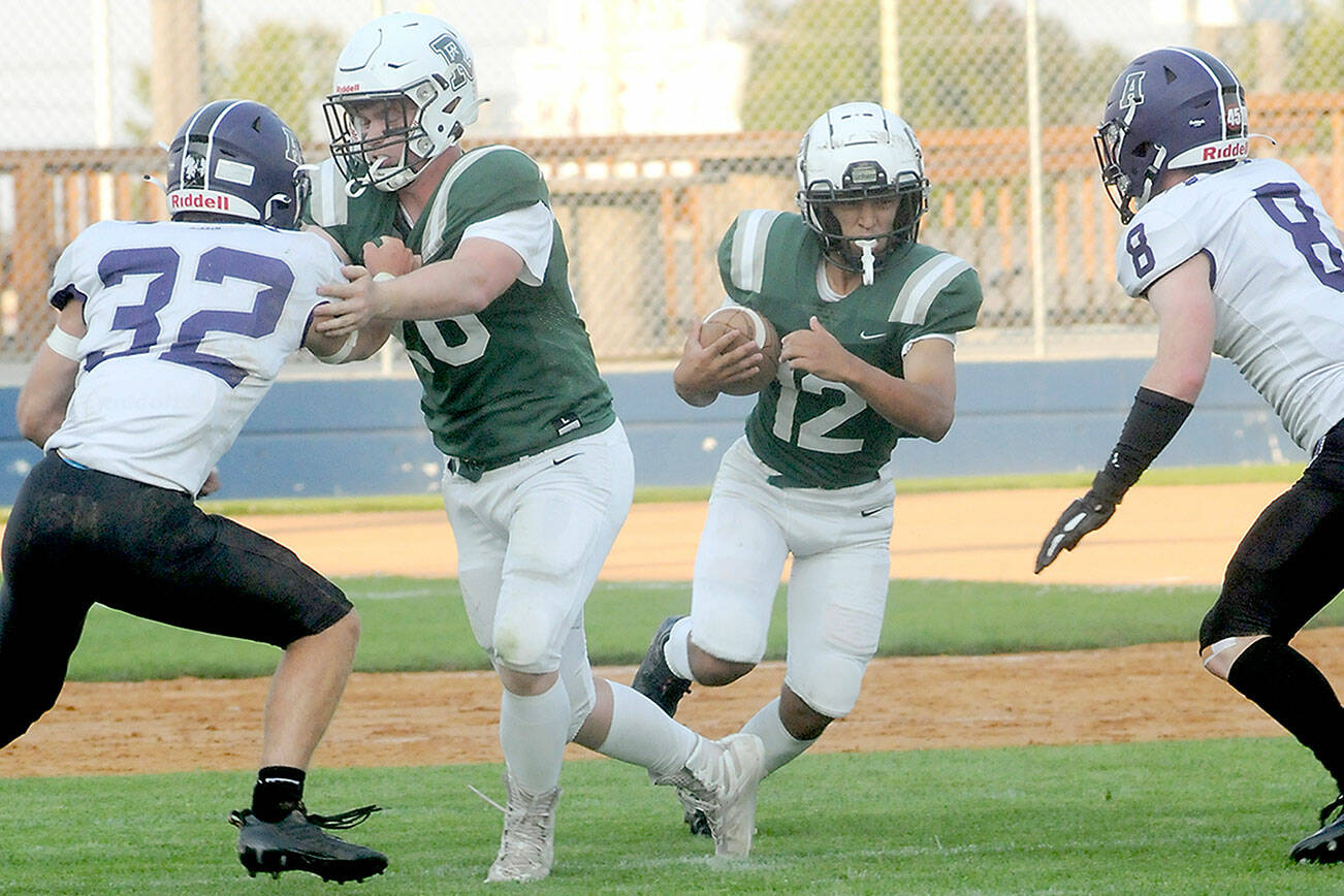 KEITH THORPE/PENINSULA DAILY NEWS
Port Angeles' Kason Albaugh, center, gets a block from teammate Landyn Jones as Anacortes' defenders Brock Beaner, left, and Braden Thomas close in during the first quarter on Friday in Port Angeles.