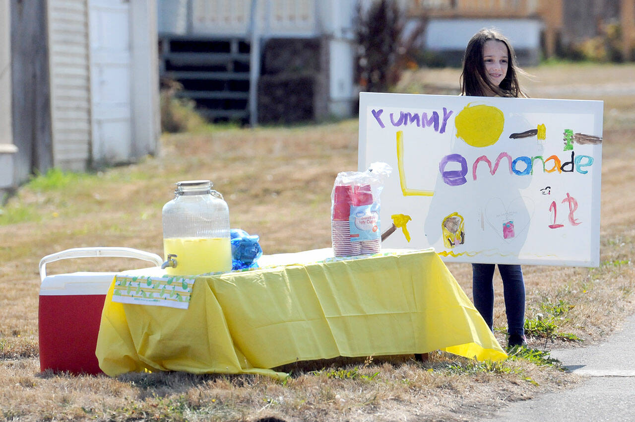 Addison Bell, 9, tries to drum up business for her lemonade stand at Fourth and Race streets in Port Angeles. The youngster said she had taken in about $70 before running out of product. She said a portion of the proceeds were slated to go to the Olympic Peninsula Humane Society with some set aside for herself. (Keith Thorpe/Peninsula Daily News)