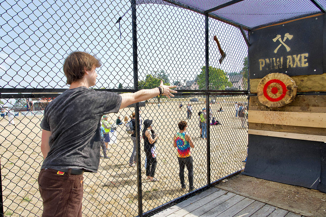 Dayton Brown, from Sammamish, aims for the bull’s eye in the PNWAXE cage during THING music and arts festival on the Parade grounds of Fort Worden State Park on Friday. THING continues today and Sunday. (Steve Mullensky/for Peninsula Daily News)