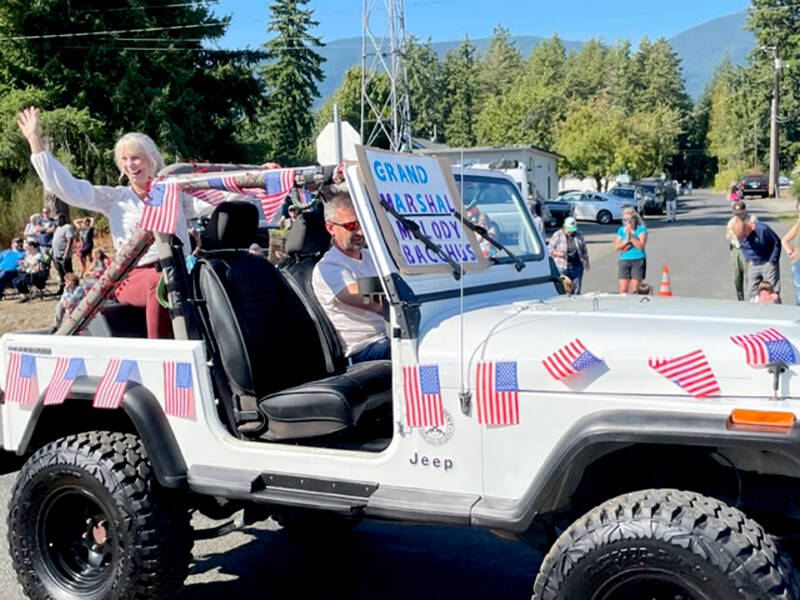 Quilcene Parade Grand Marshal Melody Bacchus waves to the crowd on Saturday, the unofficial kickoff to the annual fair. The Quilcene Oyster Half Marathon, 10K and 5K runs were held Sunday, and the arts and crafts show returned this year. (David Goetze)