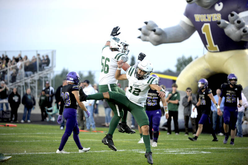 Port Angeles' Tanner Flores (56) and Kason Albaugh (12) celebrate a big play in the Rainshadow Rumble in Sequim on Friday night. The Roughriders won the game 37-10, avenging last year's last-second win by the Wolves. For a game story, go to Page A6. (Michael Dashiell/Olympic Peninsula News Group)