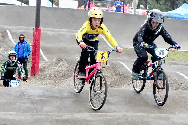 Abel Grant of Marysville (1) and Sophia McCain of Spokane (38) are in tight race in the girls division of the BMX state championships on Sunday at the Lincoln Park BMX track in Port Angeles. Hundreds of racers visited the North Olympic Peninsula for the event this weekend. (Dave Logan/for Peninsula Daily News)