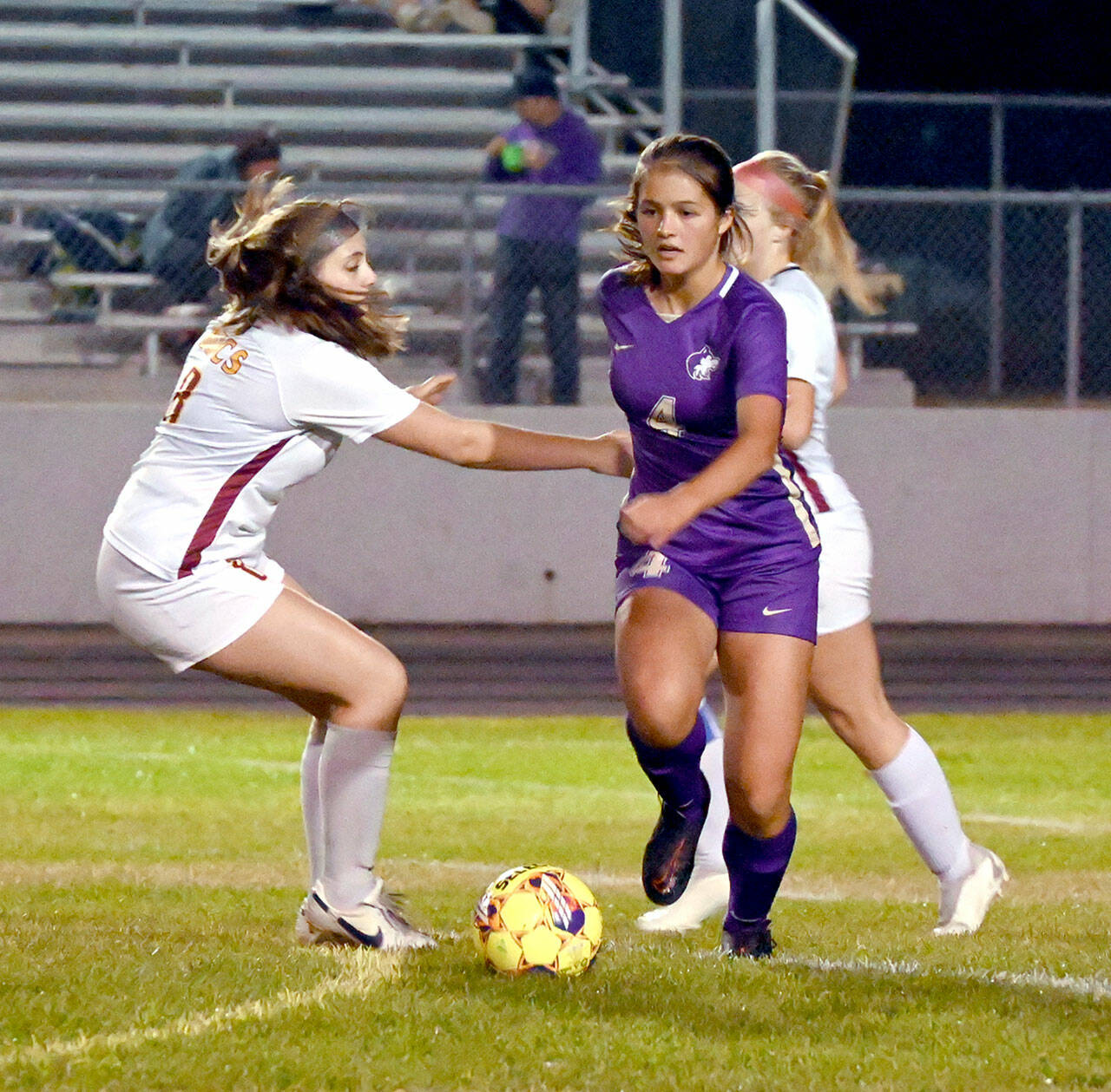 Sequim’s Raimey Brewer looks forward after outmaneuvering Kingston’s Emma Matteson for the ball during the Wolves’ 4-0 win Tuesday. (Michael Dashiell/Olympic Peninsula News Group)