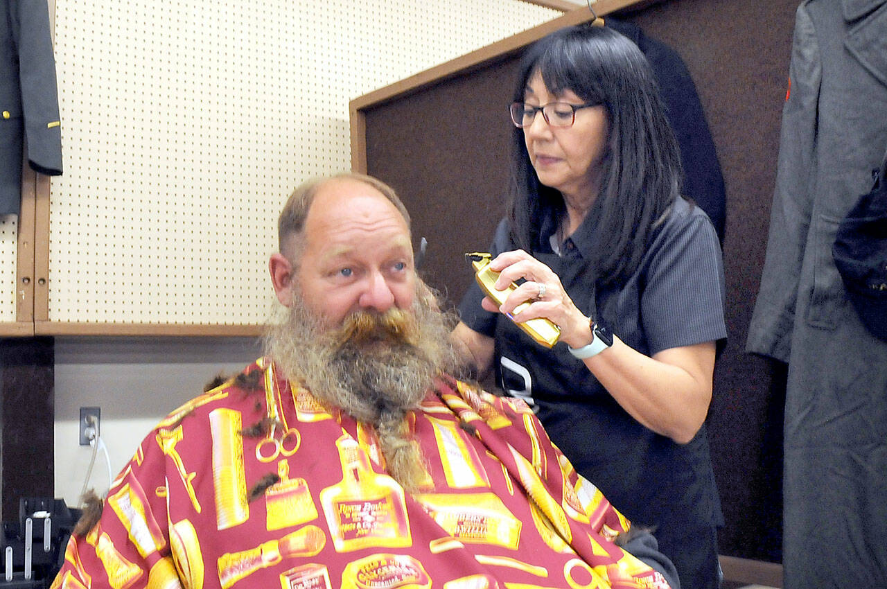 U.S. Navy veteran Brent Brant of Port Hadlock gets a haircut from Susan Gile, owner of Benny’s Barbershop in Sequim, during Thursday’s Port Angeles Stand Down at the Clallam County Fairgrounds. The event was designed to provide direct services and connect veterans to a variety of assistance organizations, as well as offer clothing, medical services and a meal. (Keith Thorpe/Peninsula Daily News)