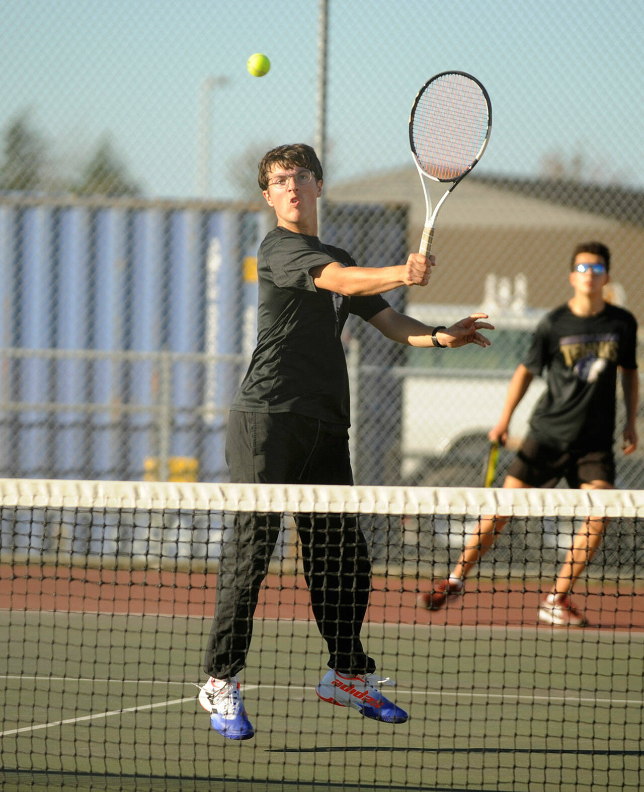 Michael Dashiell/Olympic Peninsula News Group Sequim’s William Hughes, front, returns a shot while doubles partner Tom Laschet looks on during the Wolves’ match with Kingston on Thursday.