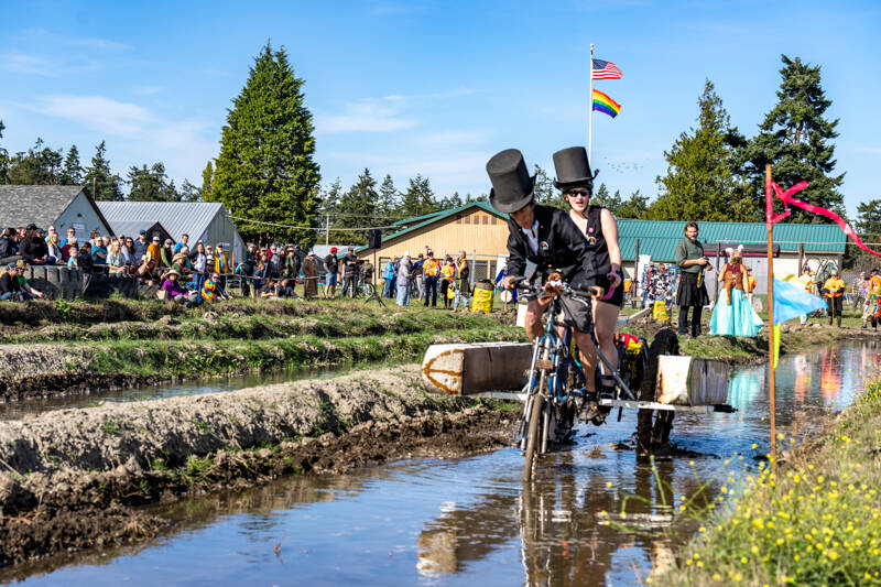 The young Brakenstein, a father/daughter team of Reed Lacy and Emily Lacy-Nichols from Corvallis, Ore., makes it to the finish line in the mud bog at the Jefferson County Fairgrounds during the Port Townsend Kinetic Skulpture and Race on Sunday. (Steve Mullensky/for Peninsula Daily News)