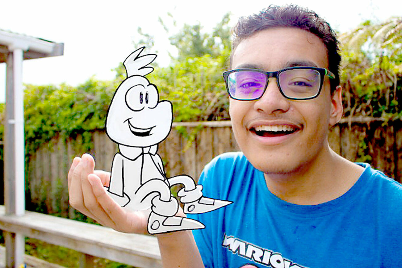 In a still from “Meet Munch Jr.,” a young man with glasses and in a blue shirt smiles. In his hand sits the animated, black-and-white figure of Mr. Munch Jr. Image provided by Sproutflix.