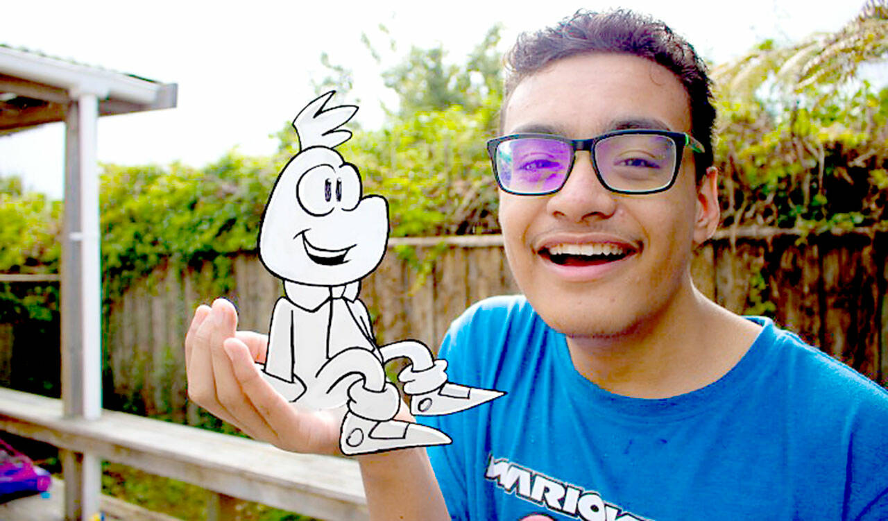 In a still from “Meet Munch Jr.,” a young man with glasses and in a blue shirt smiles. In his hand sits the animated, black-and-white figure of Mr. Munch Jr. (Image provided by Sproutflix.)