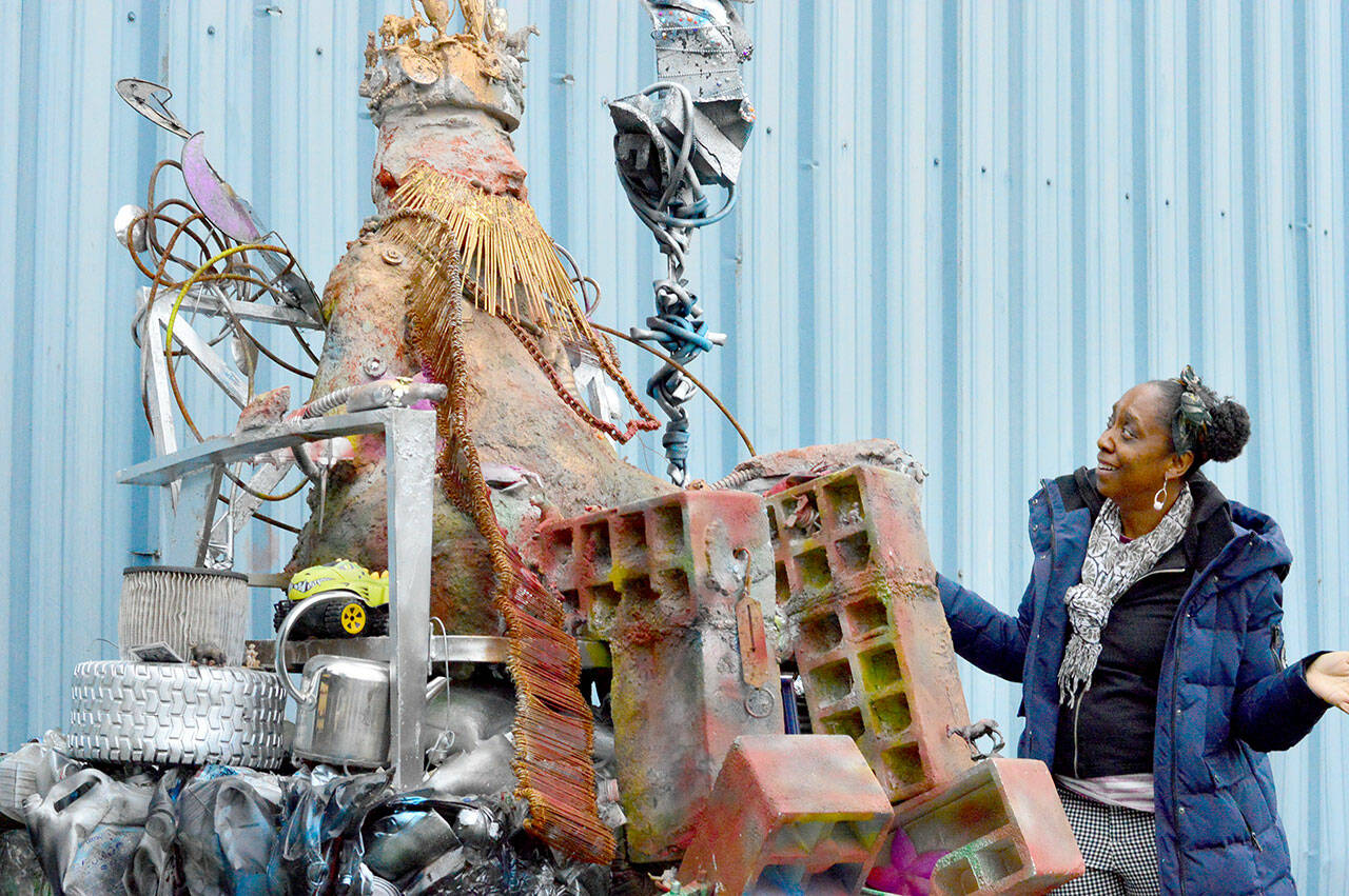 Artist Carol Rawshanna Williams looks up at her newly unveiled installation, “Dragon Trash Guardian,” at the Jefferson County Transfer Station on Monday evening. As part of the county’s Artist in Residence and Education program, Williams seeks to connect people with art, upcycling and one another. (Diane Urbani de la Paz/For Peninsula Daily News)