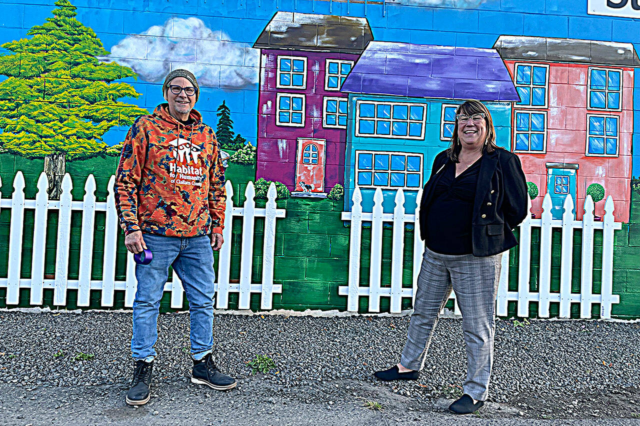 Artist Craig Robinson stands by a mural he painted at the Sequim Habitat Boutique Store in downtown Sequim in collaboration with his wife and Habitat’s chief executive officer Colleen Robinson. They said an angel wing mural has gotten a good response so far, too. (Matthew Nash/Olympic Peninsula News Group)