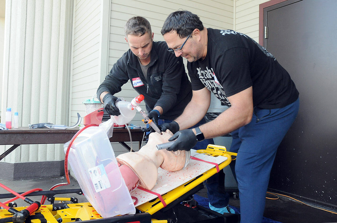 Clallam County Fire District 3 firefighter/paramedics Jeremy Church, left, and Jeff Albers practice resuscitation techniques during a training session on Thursday at Vern Burton Community Center in Port Angeles. Numerous medical personnel from fire districts 2, 3 and 4, along with the Port Angeles Fire Department and Olympic Ambulance, took part in the “Difficult Airway Course” featuring a variety of resuscitation situations in an event hosted by the Clallam County EMS Council. (Keith Thorpe/Peninsula Daily News)