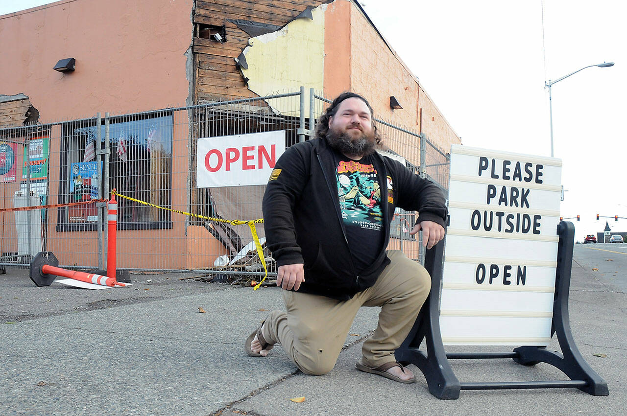 Justin Brophy, general manager of the Northwest Tobacco Emporium in Port Angeles, shows off a readerboard on Friday that takes a light-hearted view of the business’ situation. (KEITH THORPE/PENINSULA DAILY NEWS)