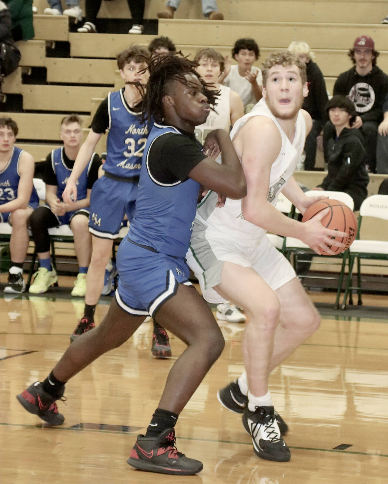 Port Angeles’ Isaiah Shamp fights to get off a shot against North Mason’s Andrew Littrean on Tuesday night in Port Angeles. Shamp finished with 17 points in a 92-57 victory. (Dave Logan/for Peninsula Daily News)