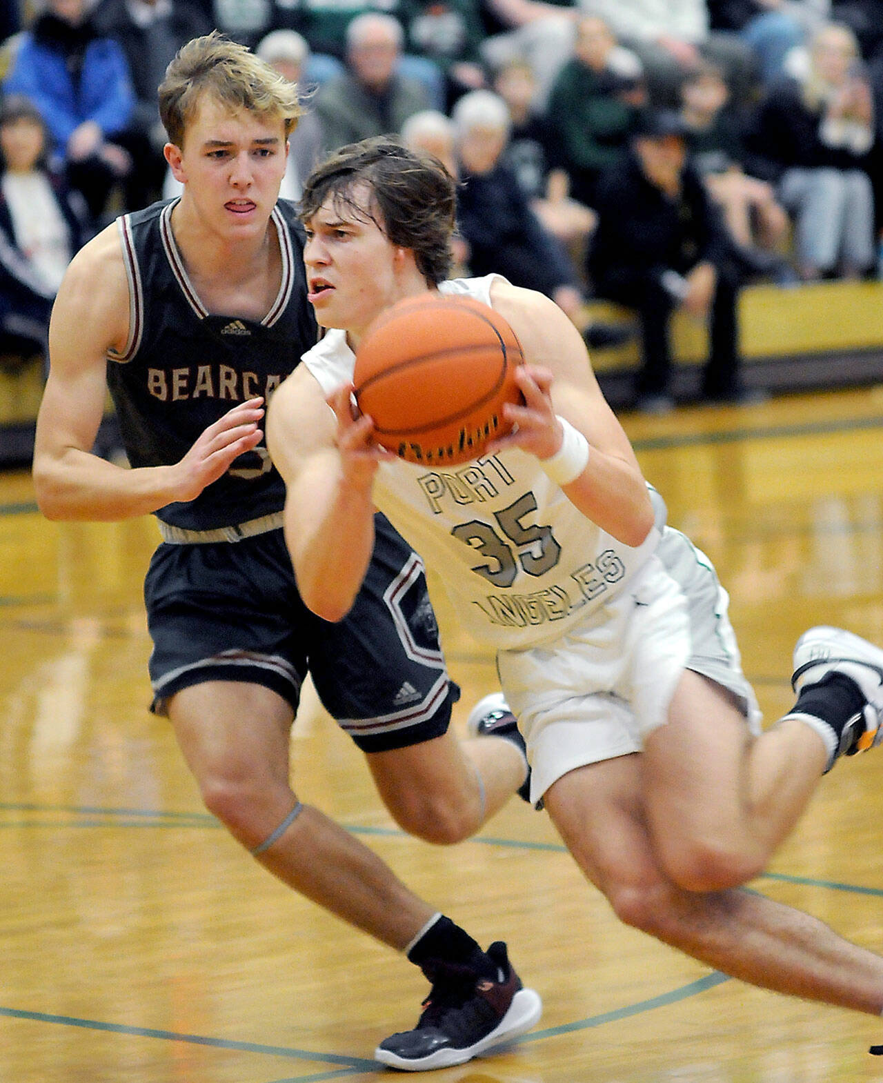 Port Angeles’ Parker Nickerson, right, charges past W.F. West’s Weston Potter during Tuesday’s game at Port Angeles High School. (Keith Thorpe/Peninsula Daily News)