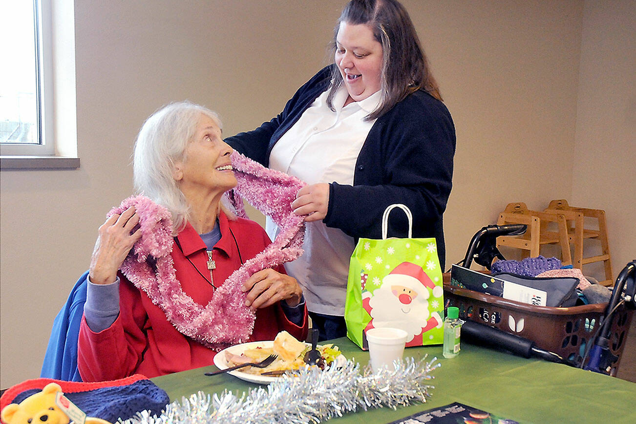 KEITH THORPE/PENINSULA DAILY NEWS
Marilyn Van Patter of Port Angeles, seated, is complimented on her decorative scarf by Capt. Crystal Birks of the Salvation Army of Port Angeles during Friday's pre-Christmas lunch at the corps facility. The meal included a clothing giveaway and gifts for participants. For information about free comunnity meals planned on Christmas Day, see Page A?