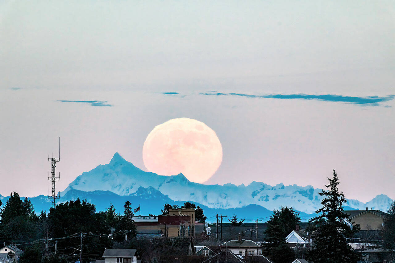 The Cold Moon, the December full moon and the last full moon of the year, rises above Mount Shuksan and over homes in Port Townsend’s Uptown neighborhood in the early evening Tuesday. (Steve Mullensky/for Peninsula Daily News)