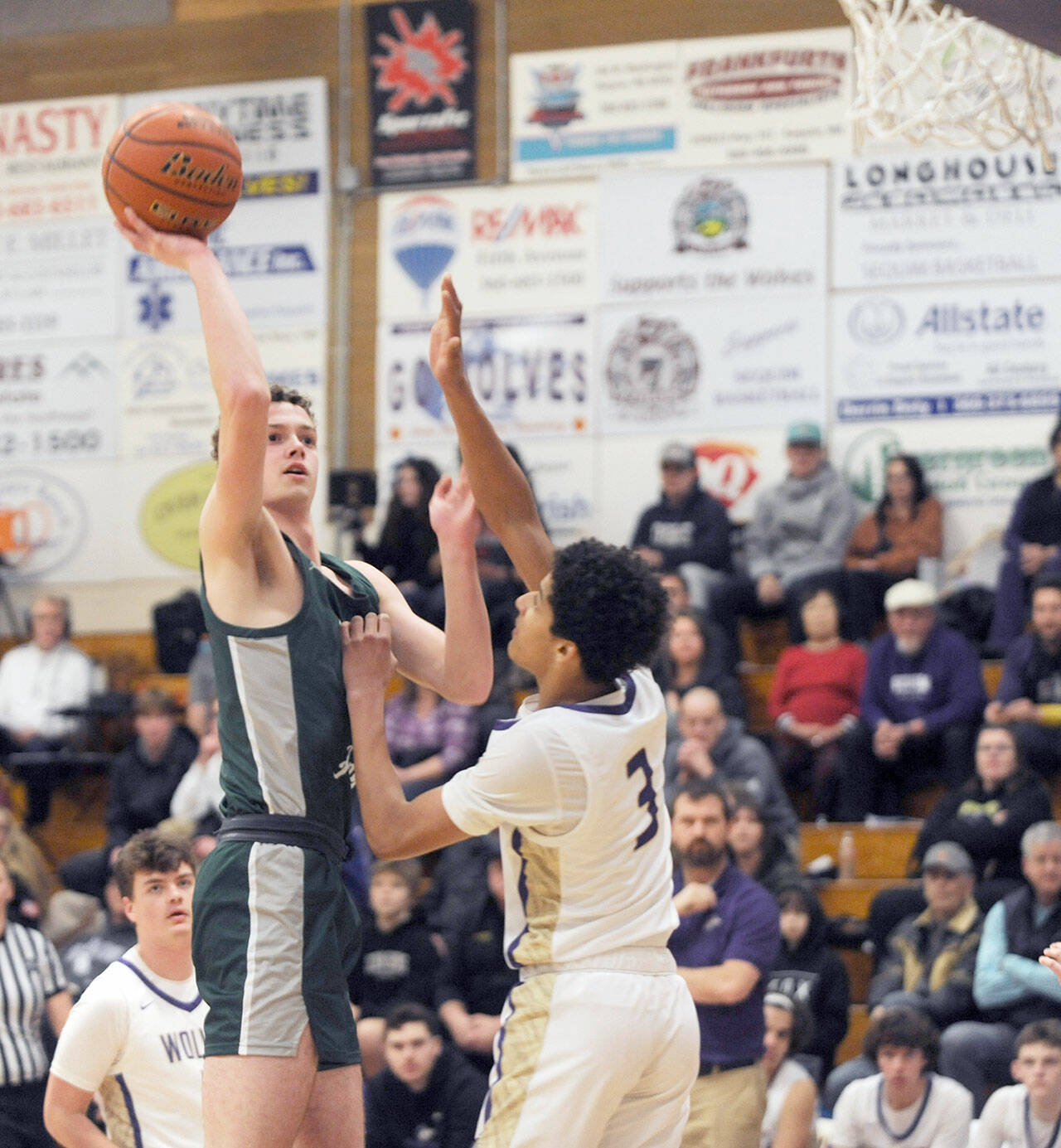 Michael Dashiell/Olympic Peninsula News Group Port Angeles’ Dallas Dunning shoots a runner while guarded by Sequim’s Solomon Sheppard during the Roughriders’ 77-52 Rainshadow Rumble rivalry victory Thursday.