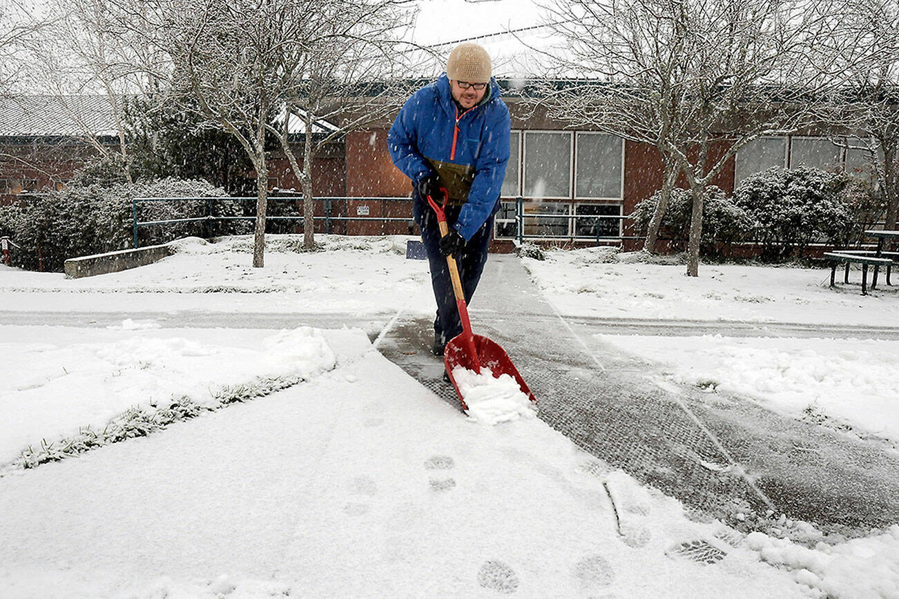 KEITH THORPE/PENINSULA DAILY NEWS
Noah Glaude, executive director of the North Olympic Library System, shovels snow from the front sidewalk at the Port Angeles Public Library after a fast and furious band of snow showers rolled across Port Angeles on Wednesday morning.