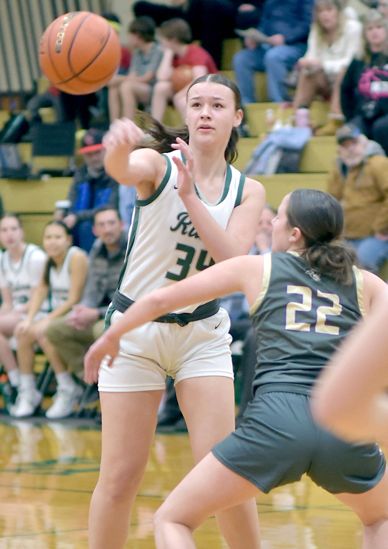 Port Angeles Lexie Smith, right, passes over the shoulder of North Kitsap’s Teegan DeVries on Tuesday evening at Port Angeles High School. (Keith Thorpe/Peninsula Daily News)