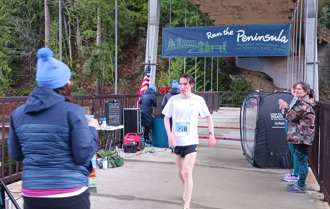 Men’s 5K winner Langdon Larson of Port Angeles crosses the finish line at the Elwha Bridge Run held Saturday morning. (Pierre LaBossiere/Peninsula Daily News)