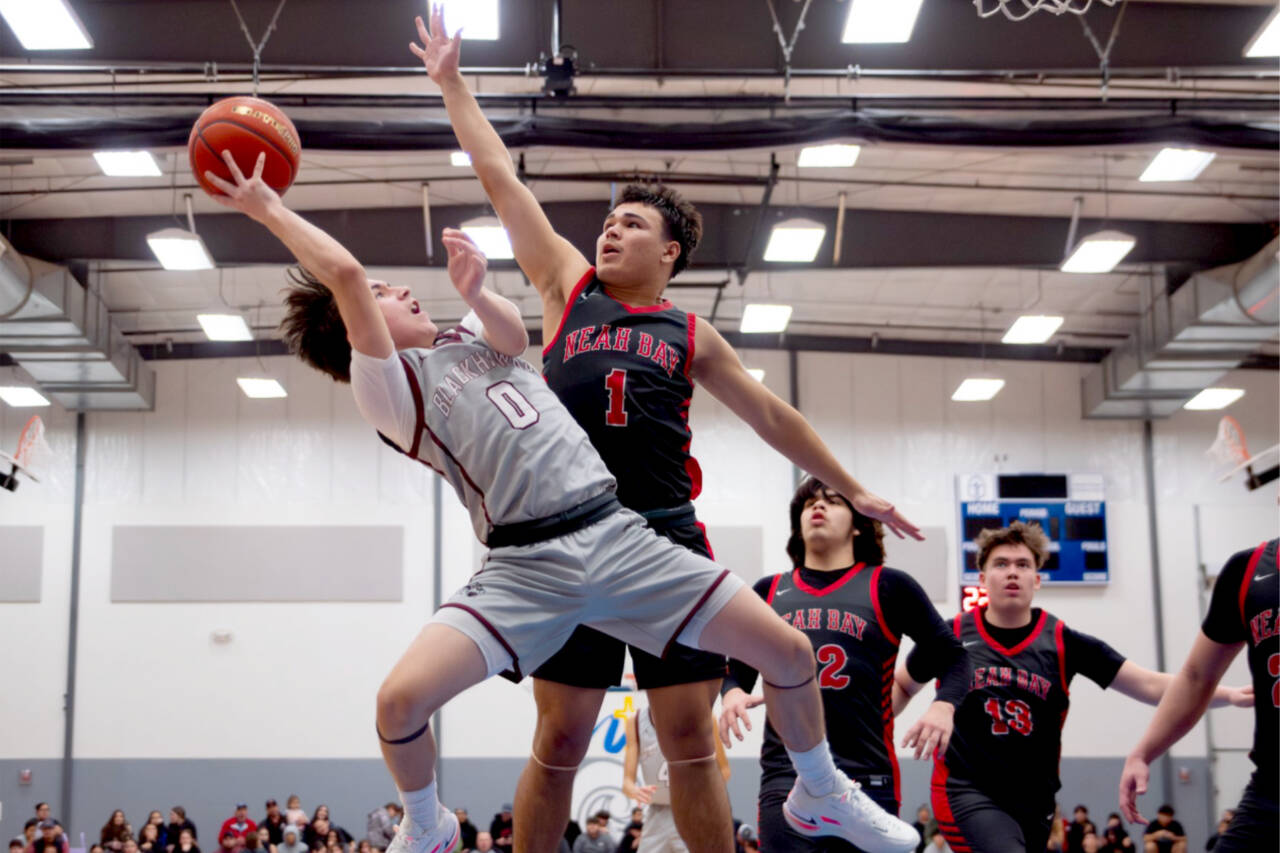 Lummi guard Jerome Toby gets fouled by Neah Bay’s Jodell Wimberly as he tries to shoot in the tridistrict championship game Saturday. (Finn Wendt/Cascadia Daily News)